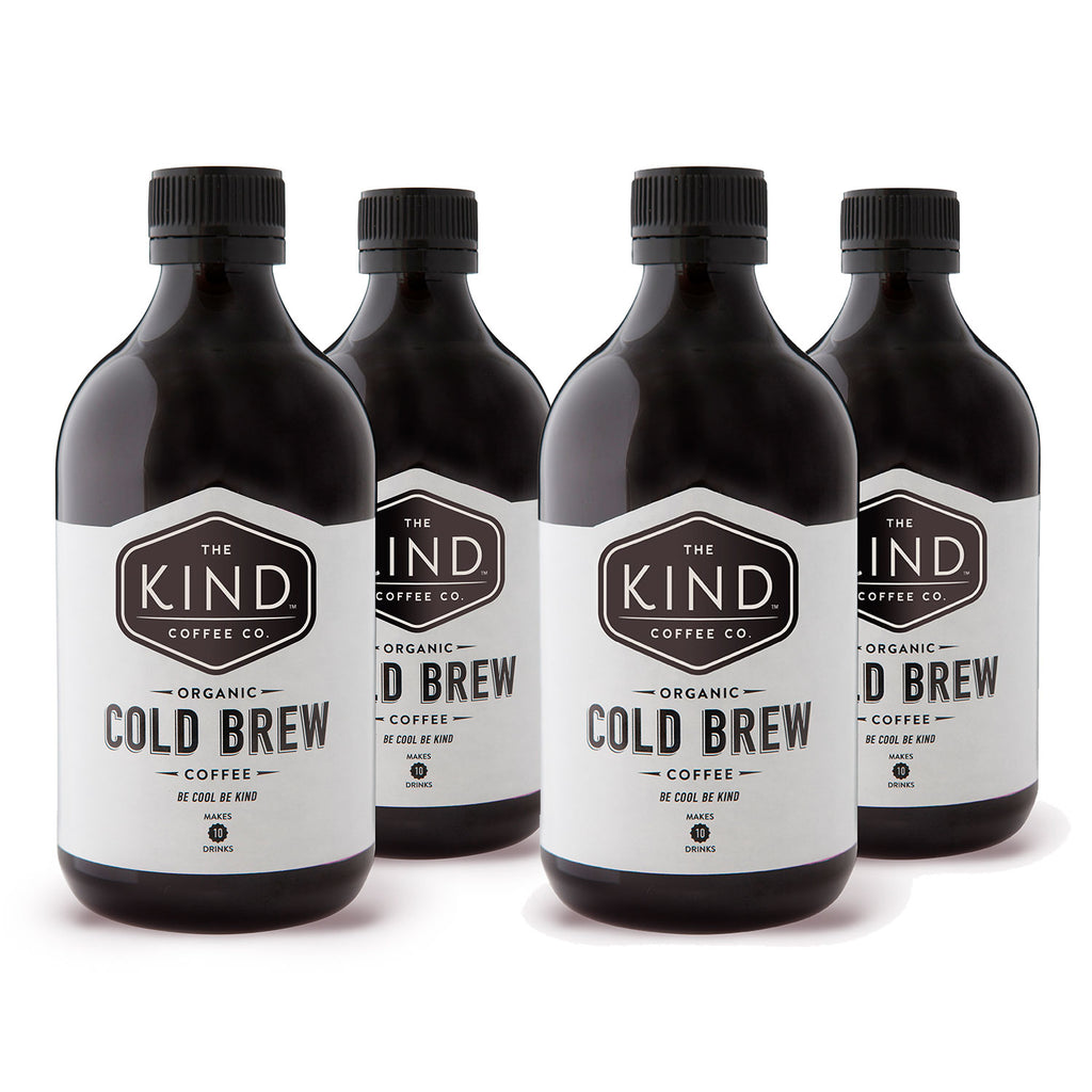 Four bottles of cold brew coffee with black labels, branded 'The Kind Coffee Co.'